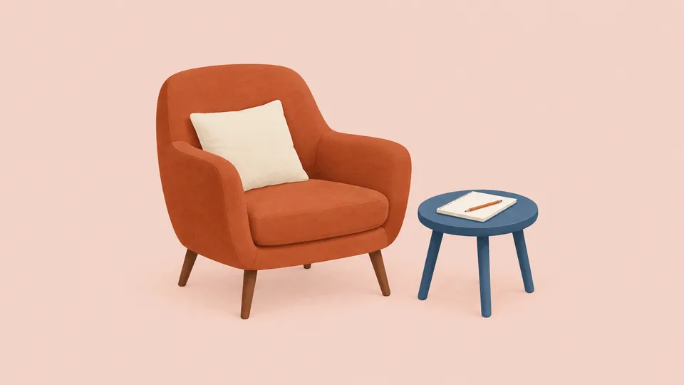 En orange stol med hvid pude og et blåt bord med notesbog og blyant.